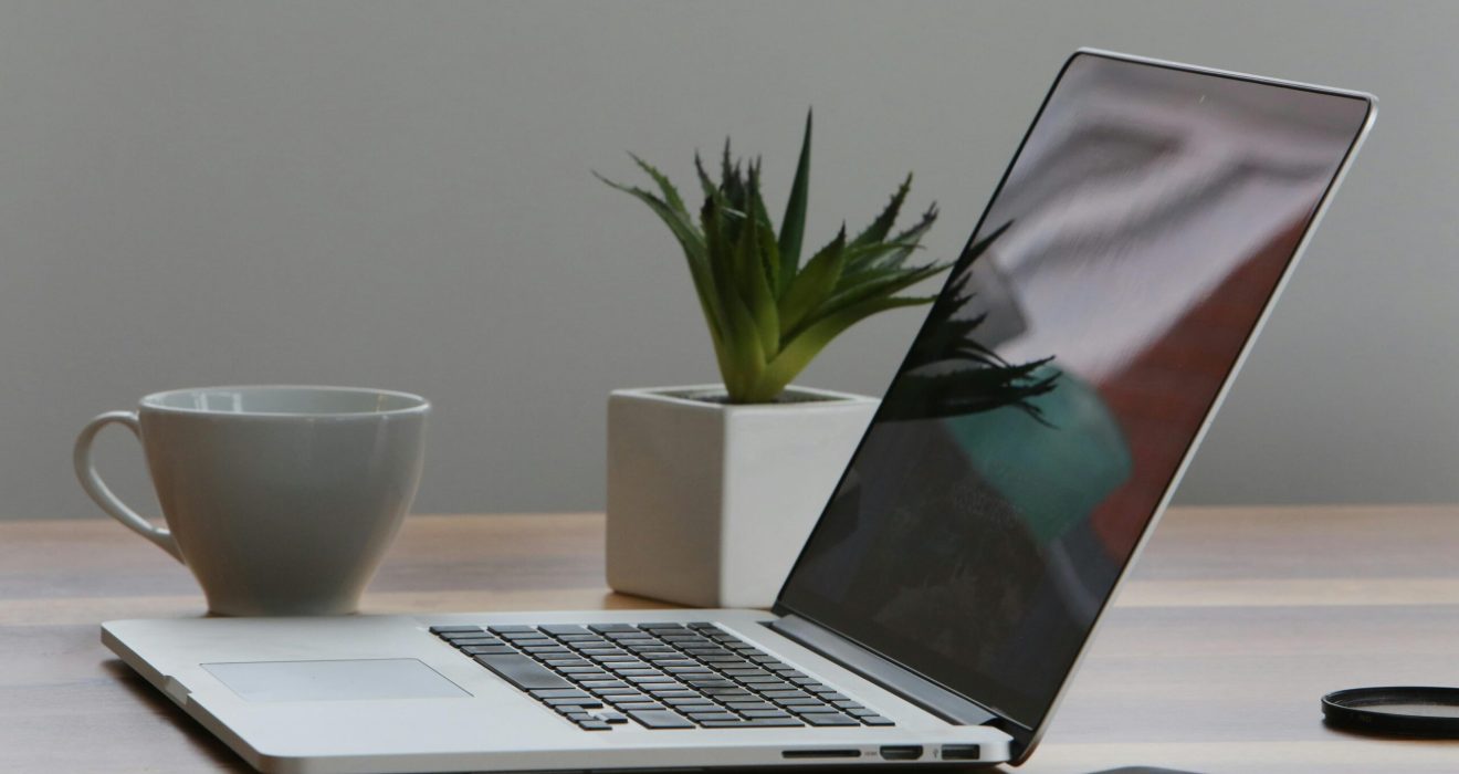 Free Minimalist home office desk with laptop, smartphone, and plant for a modern work environment. Stock Photo