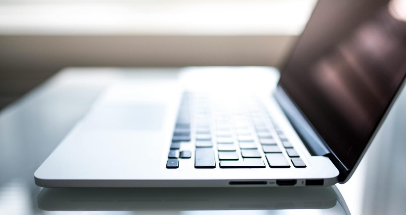 Free Elegant side view of a laptop on a glossy table with natural lighting indoors. Stock Photo